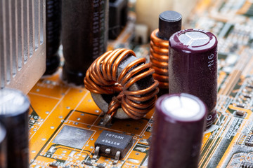 Copper coil, inductor winding part on a pc motherboard, circuit board macro, closeup. Coil whine...