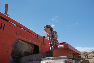 Farmer woman driving a tractor on her farm