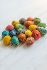 Multi-colored Easter eggs on a white wooden background
