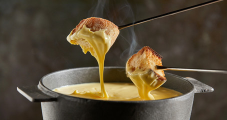 Dipping toasted bread into a hot cheese fondue
