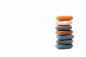 A pile, stack, tower of spa stones, simple treatment zen scene abstract symbol, copy space background. Rubber like zen pebbles isolated on white, minimalistic backdrop. Peace and tranqulity concept
