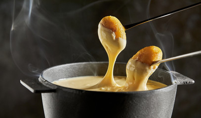 Dipping grilled baby potatoes into cheese fondue