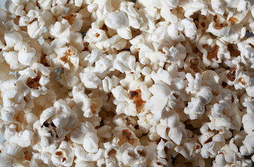 Flatlay of salted popcorn. Heap of homemade delicious popcorn. Snacks and food for a movie theater or cinema. Fastfood background. Strip texture