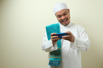 Fat Asian muslim man accessing his smart phone