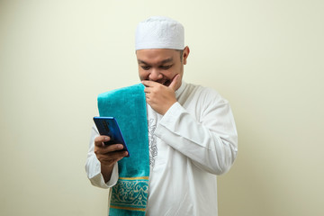 Fat Asian muslim man accessing his smart phone