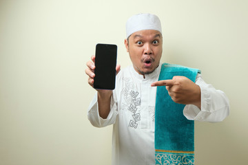 Fat Asian Muslim men looks surprised at the good news on phone