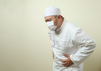 a asian muslim fat guy wearing mask feeling pain