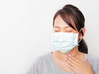 Asian woman was sick, sore throat and cough and wear green mask to prevent virus. Lady close eyes. Sign dangerous from Covid 19 spread from Chinese people in Wuhan city. Half body white background.