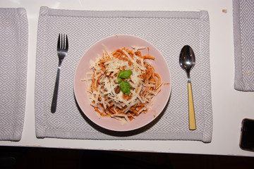 Essen Pasta mit Parmesan in Tomatensauce mitGabel und Löffel