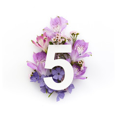 Creative layout with colourful flowers and number five. Flat lay. Top view.