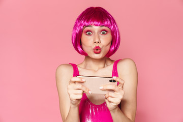 Image of happy girl wearing wig playing video games on cellphone