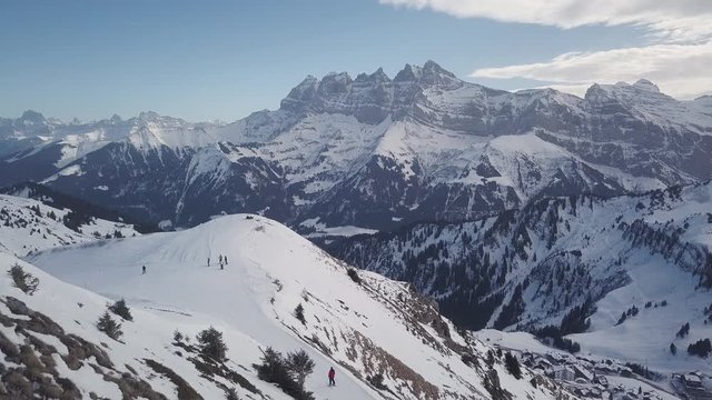 Aerial - Drone panoramic view of skiers and the whole ski resort and guys sitting with their mountains in Portes Du Soleil in 4K
