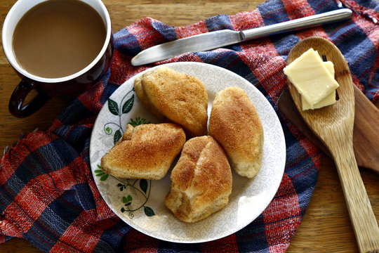Freshly baked Filipino bread called Pan de sal or Bread of Salt, coffee, slices of cheese on a table