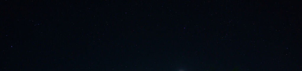 Panorama blue night sky milky way and star on dark background.Universe filled with stars, nebula and galaxy with noise and grain.Photo by long exposure and select white balance.Dark night sky.