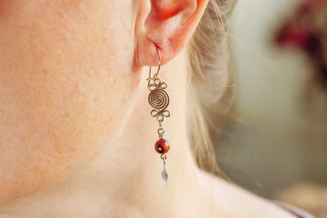 Female ear wearing tiny elegant metal wire stone bead earring