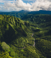 Beautiful Scenic Aerial View of Mountains in Kauai, Hawaii during clear summer weather with lush greenery 