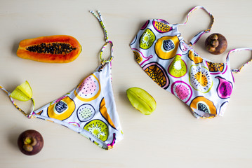 Joyful swimming clothes for pool and beach at tropical vacation resort. White color fruit print swimingwear papaya, maracuja, mangosteen, summer vacation,close-up