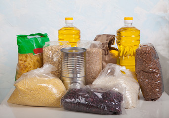 A set of products from cereals, legumes, pasta, canned food and vegetable oil in a bottle on a light background. Help. Charity. Social