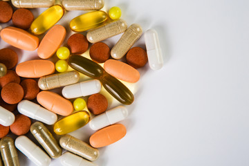 Heap of medicine colored pills, tablets and capsules on a white background