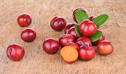 Bright red plums on old wood background