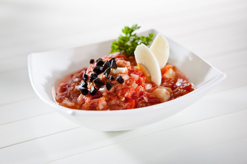 Tomato and egg salad with a black olives and parsley
