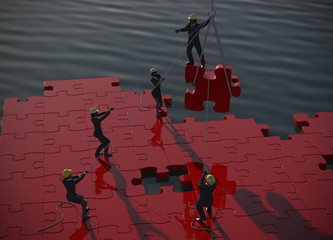 Red Jigsaw puzzle being built by teamwork at dawn by the ocean.