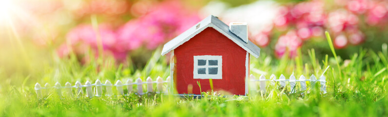 red wooden house on the grass in garden