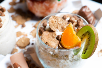 Fresh oatmeal and rice porridge with a beautiful serving and fruit. Bananas, berries, oranges and kiwi. Healthy and nutritious breakfast for children and adults. Different cereals
