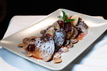 Juicy fritters with fruit for breakfast. Tasty cheesecakes with jam and bananas. Beautiful food from the restaurant cooked by a chef cook. Sweet dessert. A dish of flour and eggs.