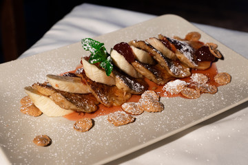 Juicy fritters with fruit for breakfast. Tasty cheesecakes with jam and bananas. Beautiful food from the restaurant cooked by a chef cook. Sweet dessert. A dish of flour and eggs.