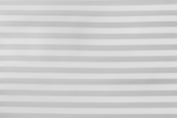 Light gray striped blurred background. Motion texture. Abstract horizontal lines wallpaper