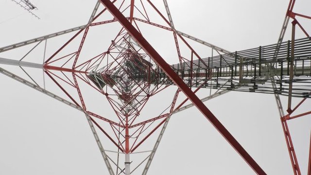 Under and rotation of Tower for telecommunications television broadcast cell phone or radio and satellite on the mountain peak. Slow Motion 4K 29.97fps
