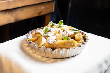 Juicy banana pie. Delicious Thanksgiving apple pie with mint or basil. Baking in the oven. Pie with banana. Sweet cupcake with baked fruit sprinkled with powder.