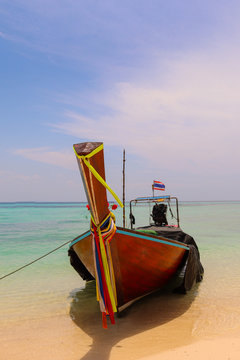 Barco tailandes parado en una playa paradisiaca