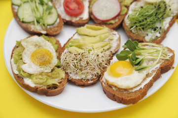Sandwiches with vegetables, eggs, avokado and micro greens on stone background. Healthy food.