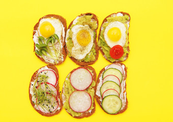 Sandwiches with vegetables, eggs, avokado and micro greens on stone background. Healthy food.