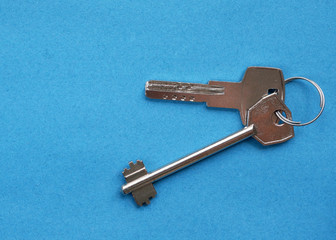 House keys on a blue background close-up.