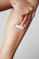 Taille, hanche, ventre et jambe d'une femme sur fond neutre