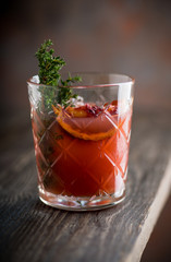 Old-fashioned cocktail with blood oranges and thyme on the rustic background. Selective focus. Shallow depth of field.