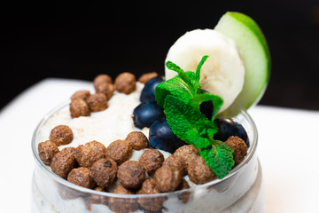 Fresh oatmeal and rice porridge with a beautiful serving and fruit. Bananas, berries, oranges and kiwi. Healthy and nutritious breakfast for children and adults. Different cereals