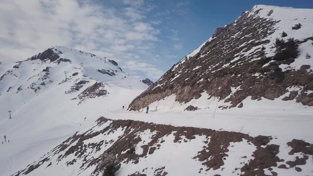 Aerial 4K - Drone travel shot of skiers and snowboarders at the skislope/resort Portes Du Soleil (Avoriaz) in France on the border with Switzerland.