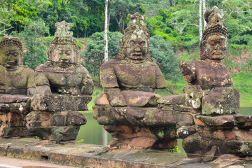 Demon statues (asuras) along the pathway leading to Bayon Temple over Siem Reap River. Angkor Temples in Cambodia