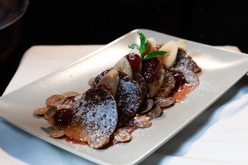 Juicy fritters with fruit for breakfast. Tasty cheesecakes with jam and bananas. Beautiful food from the restaurant cooked by a chef cook. Sweet dessert. A dish of flour and eggs.