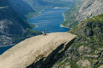 Trolltunga. Troll language in Norway. Rocky ledge above the fjord. Natural landmark of Norway. Girl...
