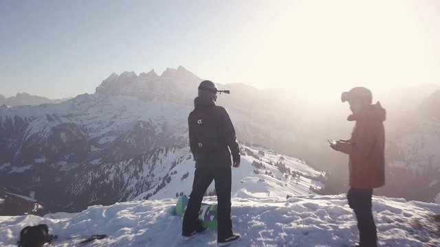 Aerial 4K - A really close passing through panormic drone shot of 2 skiers standing on the edge of a mountain at the skislope/resort Portes Du Soleil (Avoriaz) in France on the border with Switzerland