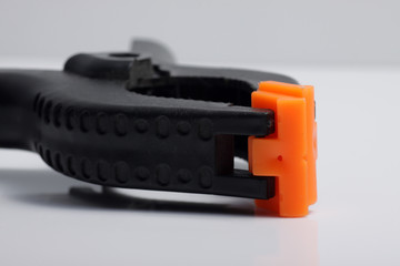 Close up shot of black plastic clamp on a white isolated background