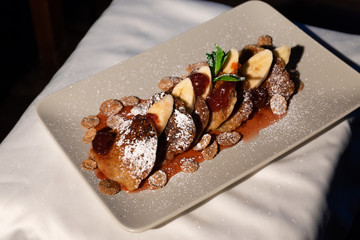 Juicy fritters with fruit for breakfast. Tasty cheesecakes with jam and bananas. Beautiful food from the restaurant cooked by a chef cook. Sweet dessert. A dish of flour and eggs.