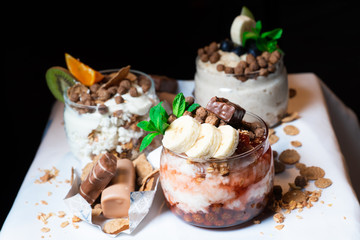Fresh oatmeal and rice porridge with a beautiful serving and fruit. Bananas, berries, oranges and kiwi. Healthy and nutritious breakfast for children and adults. Different cereals