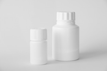 White Plastic Pill Bottles On A Gray Surface