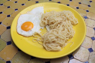 Assiette jaune avec oeuf au plat et pâtes spaghettis - Département du Rhône - France